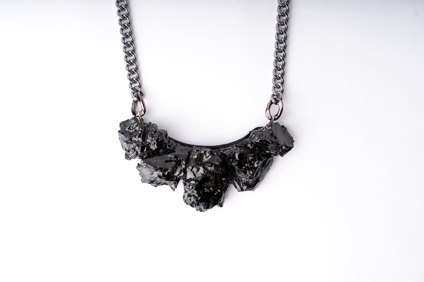 Every necklace is made from silver and hard coal, both displaying the hidden charm of "black gold" There are no two identical necklaces. Each item is unique and handmade thanks to the material itself. You will get noticed everywhere. The back is made with a silk layout. As a gift, you get a story about coal, and how it was made.