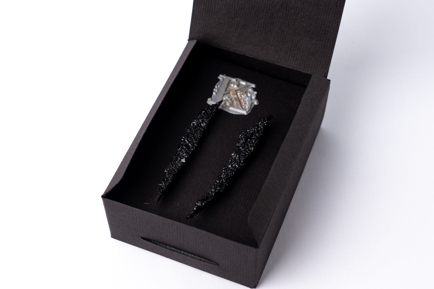 The Earrings KUOLMi Creation Style are made of 10 million-year-old stone. Due to its black luster and special organic shape, each piece is unique and unrepeatable in its appearance. It is made entirely by hand from coal and stainless steel. Jewelry is packaged in a gift box. The story about coal from which the jewelry was made is included as a gift. Simple. Elegant. Mighty and powerful.
