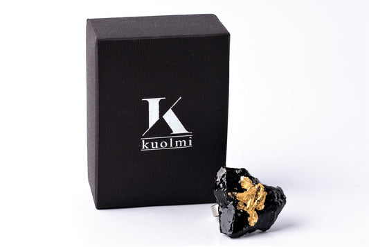 The KUOLMi handmade ring is a fantastic accessory that makes the look perfect. The 10 million-year-old stone will shine on your hand with all its brilliance. The ring is made of coal and stainless steel. It is adjustable in size. The image is symbolic because each piece is handmade, unrepeatable, and unique. The ring is packaged in gift packaging with an added description of the coal story.
