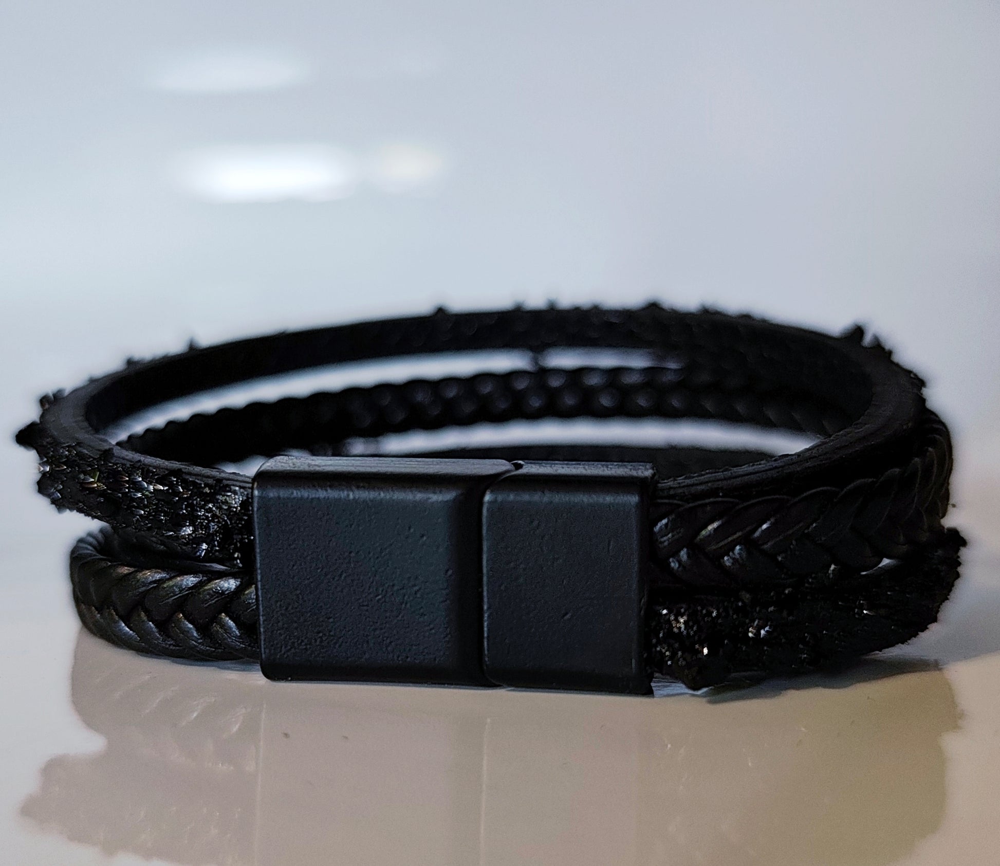 Leather Bracelet with Coal Accent
A refined blend of heritage and modern design. Handcrafted from premium leather, this bracelet features a unique weave of four straps and a symbolic element – natural Slovenian coal.

Available in two finishes:
🖤 Matte coal – for understated elegance
✨ High-gloss coal – for a bold, refined contrast

Details:
– Length: 18 cm
– Width: 2 cm
– Unisex: suitable for women and men
– Comes in a premium gift box
– Includes a story card about the coal's meaning and origin
