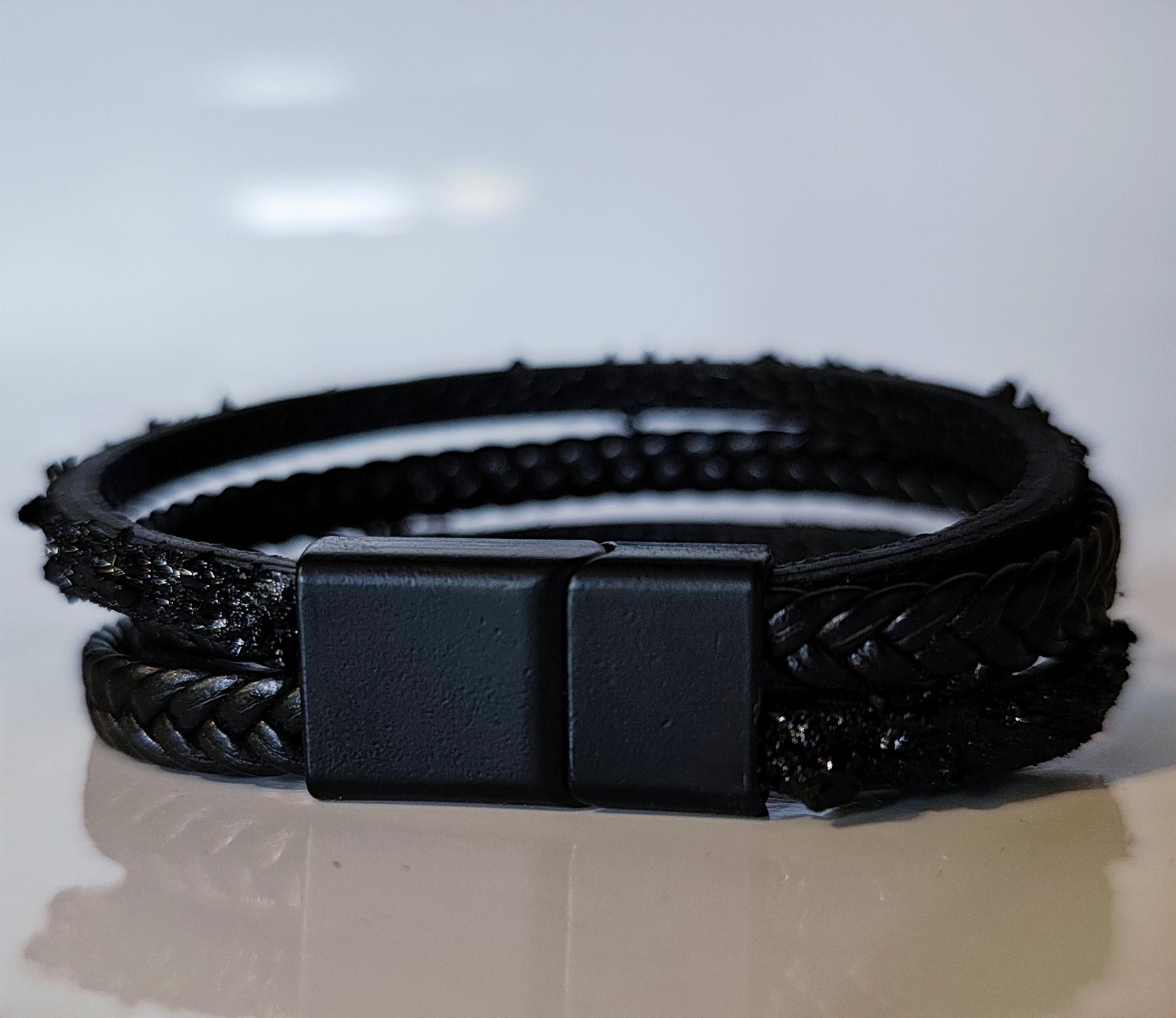 Leather Bracelet with Coal Accent
A refined blend of heritage and modern design. Handcrafted from premium leather, this bracelet features a unique weave of four straps and a symbolic element – natural Slovenian coal.

Available in two finishes:
🖤 Matte coal – for understated elegance
✨ High-gloss coal – for a bold, refined contrast

Details:
– Length: 18 cm
– Width: 2 cm
– Unisex: suitable for women and men
– Comes in a premium gift box
– Includes a story card about the coal's meaning and origin
