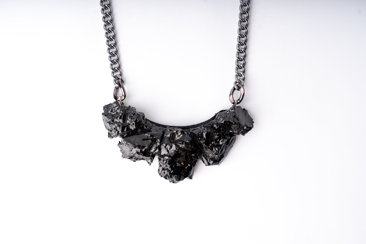Every necklace is made from silver and hard coal, both displaying the hidden charm of "black gold"  There are no two identical necklaces. Each item is unique and handmade thanks to the material itself.  You will get noticed everywhere. The back is made with a silk layout.   As a gift, you get a story about coal, and how it was made. 